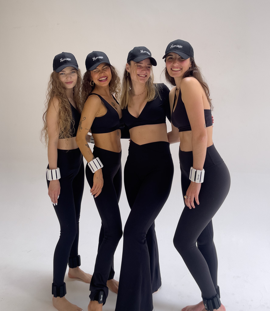 Coach with 3 other girls, all wearing black workout outfit.